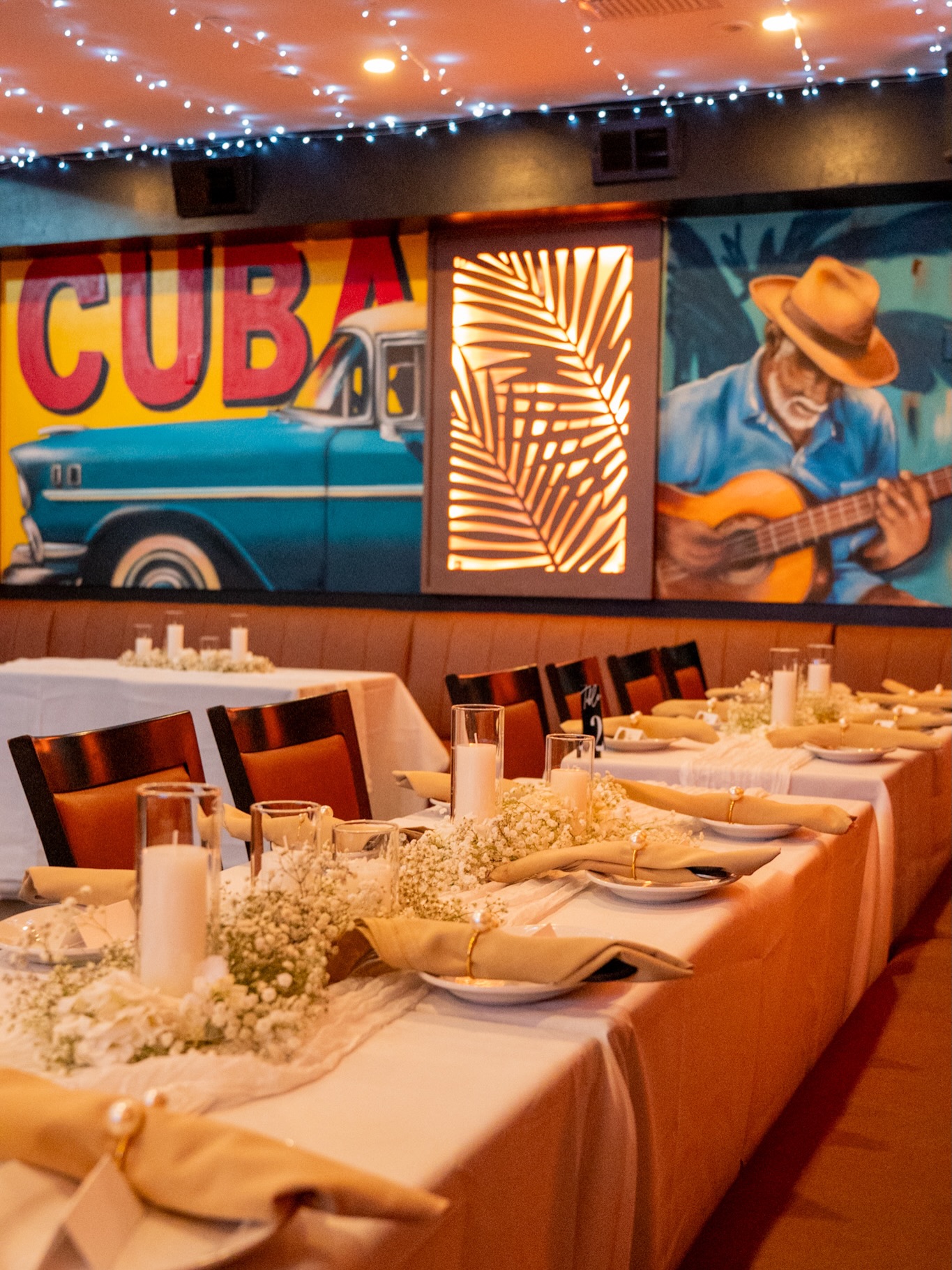 Mambo dining room set for a private event with Cuban murals and string lights