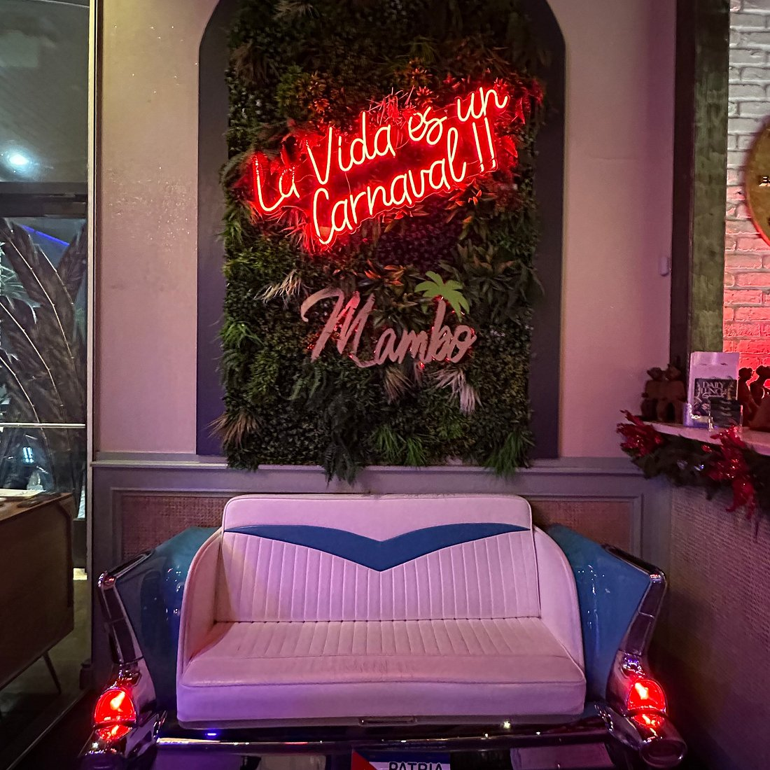 Mambo lounge neon sign with a vintage car couch